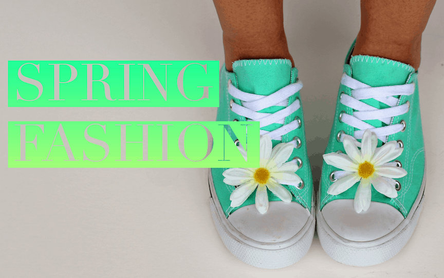 A lady is showing off spring fashion in a pair of pastel green Chuck Taylor's with a daisy in the laces of each shoe.