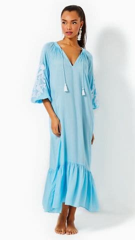 Lady wearing a blue maxi cover-up dress with tassels