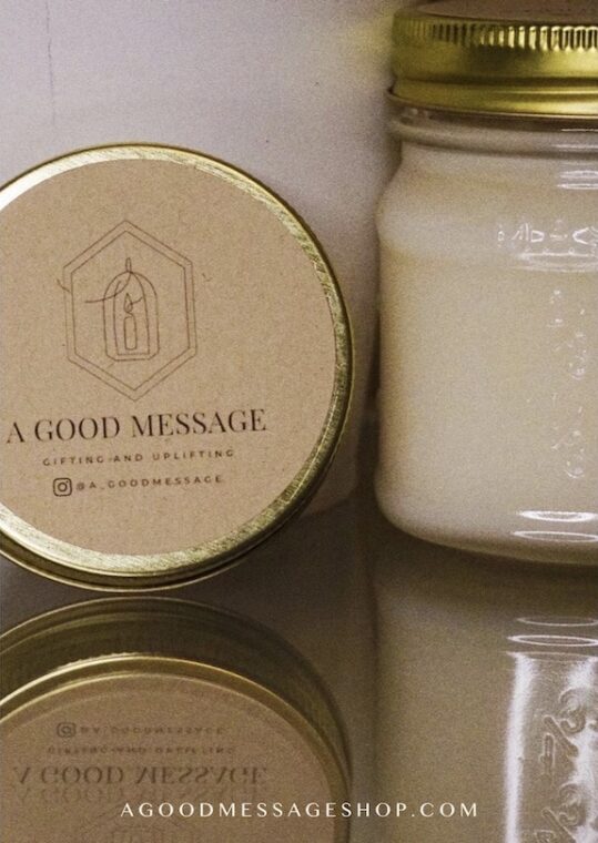 Two candles in mason jars are displayed on a mirror for this black owned business, A Good Message.