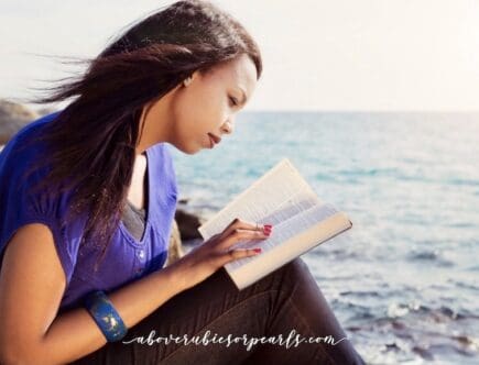 A lady reading the Bible by the ocean