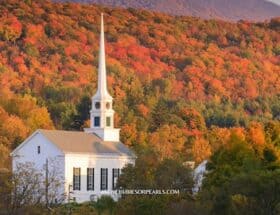 A white church with fall foliage all around