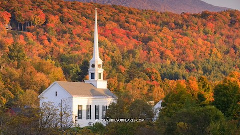 A white church with fall foliage all around