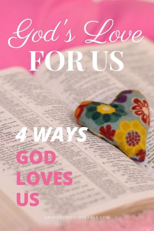 A heart-shaped plush squeezie decorated with flowers is on top of an open Bible. the Bible is laying on a pink bed.