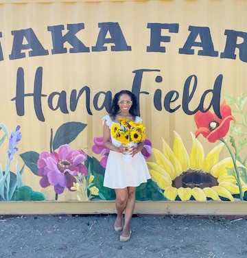 posing in front of the Hana Field mural