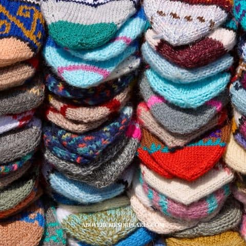 Stacks of colorful knitted socks to be donated to the homeless during Socktober