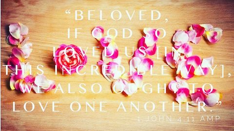 Love is spelled out in flower petals.  The text on top is the command to love one another as God loved us.