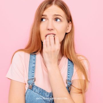Lady, anxiously comparing herself to others, biting her nails