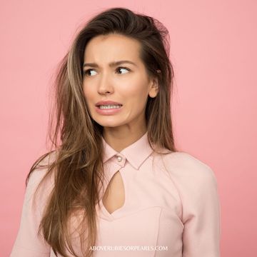 A lady in a pink collared blouse grimaces in comparison