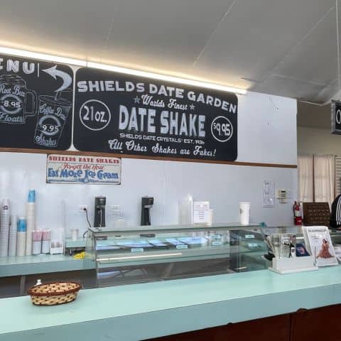Shields Date Garden café counter displaying snacks and popular date shakes, with the gift shop visible behind.