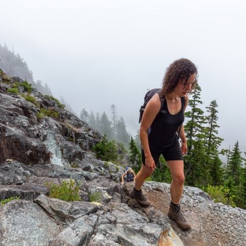 Woman hiking confidently in the mountains, representing walking in God-given confidence and trusting His guidance.